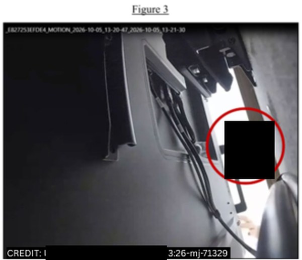Korrelig camerabeeld van achter een tv: kabels en een tv-beugel, rechts kijkt een man om de rand naar binnen. Bovenaan staat een bestandsnaam met MOTION en de datum 2026-10-05. Het gezicht is met een zwart vlak afgedekt.