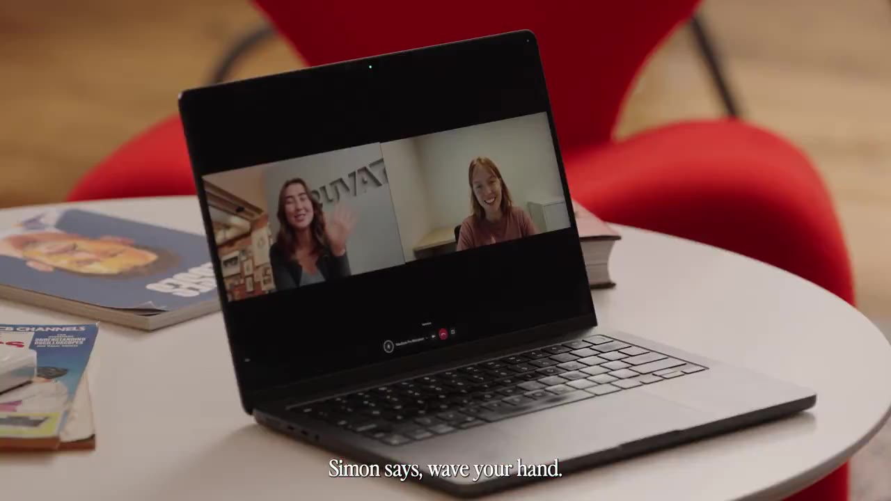 Laptop op een tafel met een videogesprek tussen een vrouw en een AI-persona die als een gewone deelnemer in beeld zit